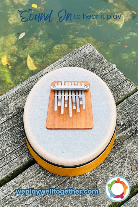 Hokema Sansula Basic in the Soundscape elemental Aqua tunning on a wooden plank in front of water |weplaywellltogether