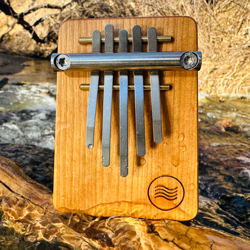 Hokema B5 Kalimba Aqua tuning next to a flowing river | We Play Well Together