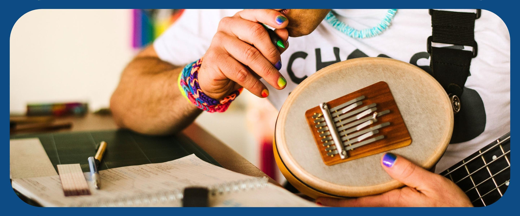 A man showing Hokema Sansula Basic Kalimba, an instrument where a wooden block with tines is attached to a small drum head producing a prolonged, soft tone. | weplaywelltogether   