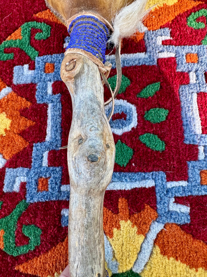 Hand-made rattle with animal faces on the  stem and river rocks inside / weplaywelltogether