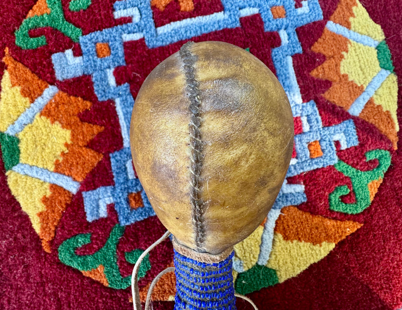 Hand-made rattle with animal faces on the  stem and river rocks inside / weplaywelltogether