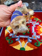 Hand-made rattle with animal faces on the  stem and river rocks inside / weplaywelltogether