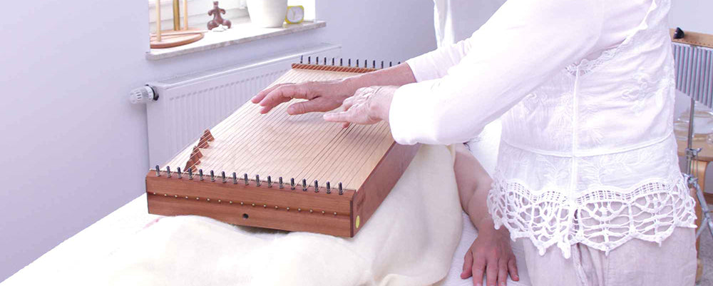 Martina Gläser-Böhme demonstrating therapeutic placement of the feeltone Monolina body monochord during a sound massage session