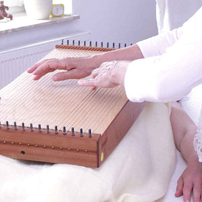 Martina Gläser-Böhme demonstrating therapeutic placement of the feeltone Monolina body monochord during a sound massage session