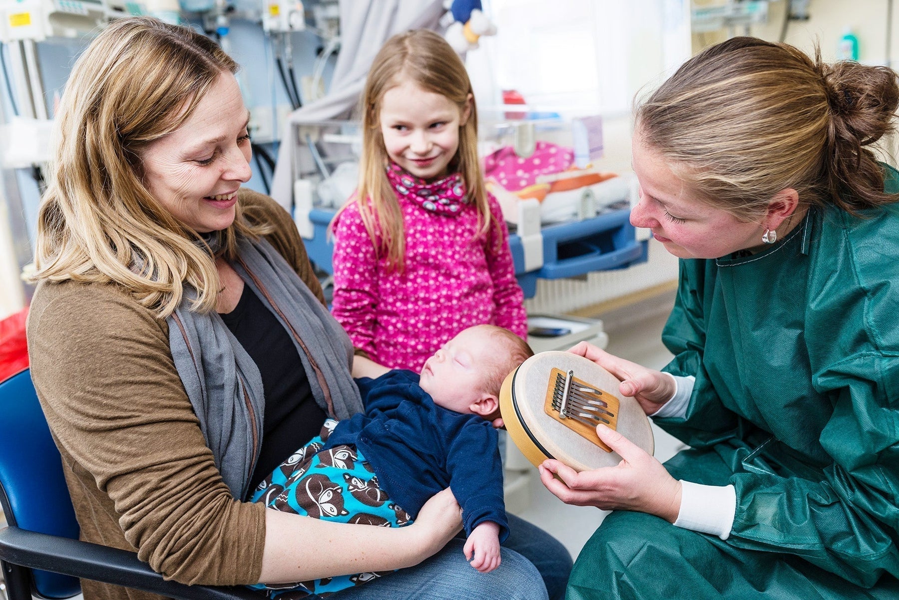 Music therapist Susann Kobus playing the Hokema Sansula for a mother and baby in a neonatal unit