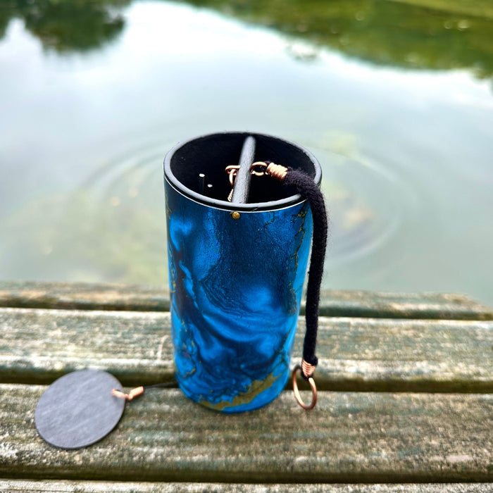blue colored Zaphir chime sitting on a wooden floor |Weplaywelltogether blue Zaphir chime in Aqua tuning on a wooden bench in front of water