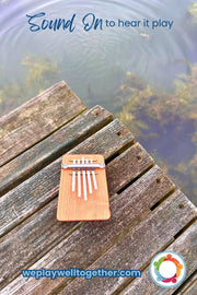 HOKEMA B5 KALIMBA - Elemental Soundscapes Water Collection (D-minor) sitting on a wooden bench in front of a lake