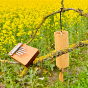 Hokema B5 kalimba and Koshi Aria chime in nature with yellow flowers  | weplaywelltogether