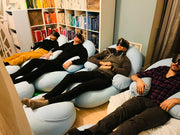 Multiple people laying comfortably on bean bags and having eye masks on  | weplaywelltogether