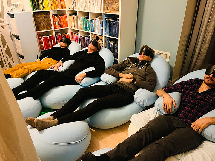 Multiple people laying comfortably on bean bags and having eye masks on  | weplaywelltogether
