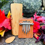 Koshi Ignis and Hokema B5 Fire kalimba on a rock with fall leafs | weplaywelltogether