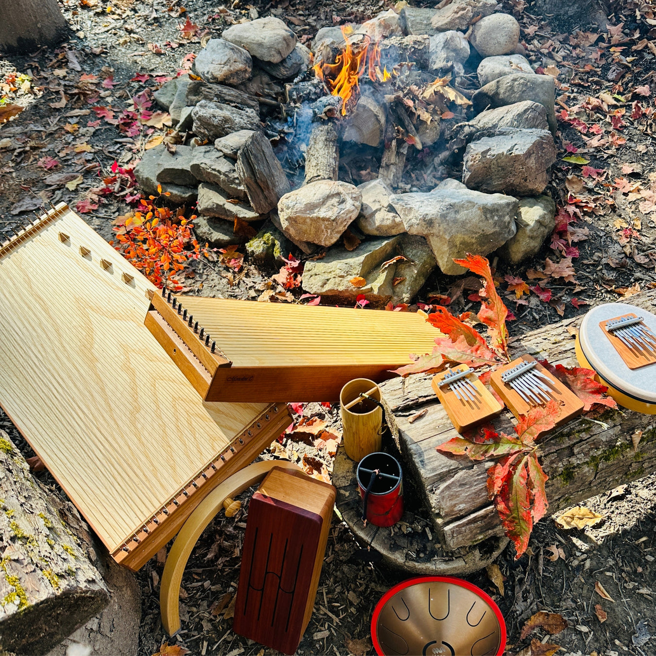 feeltone monochords, Hokema Sansula Basic, B0 and B5 kalimbas, feeltone Tinka Tong wooden tongue drum, Zenko metal tongue drum Ignis, koshi chime and red Zaphir chime by the fire | weplaywelltogether