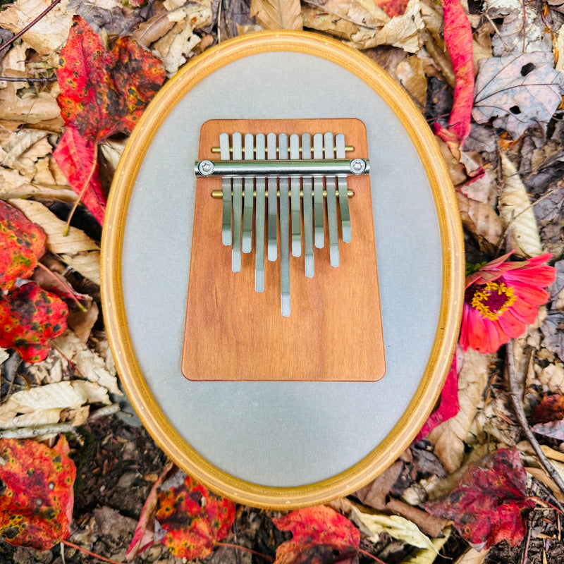 Hokema Sansula Melody kalimba has a mounted drum head and 11 tines on a wooden block. | weplaywelltogether