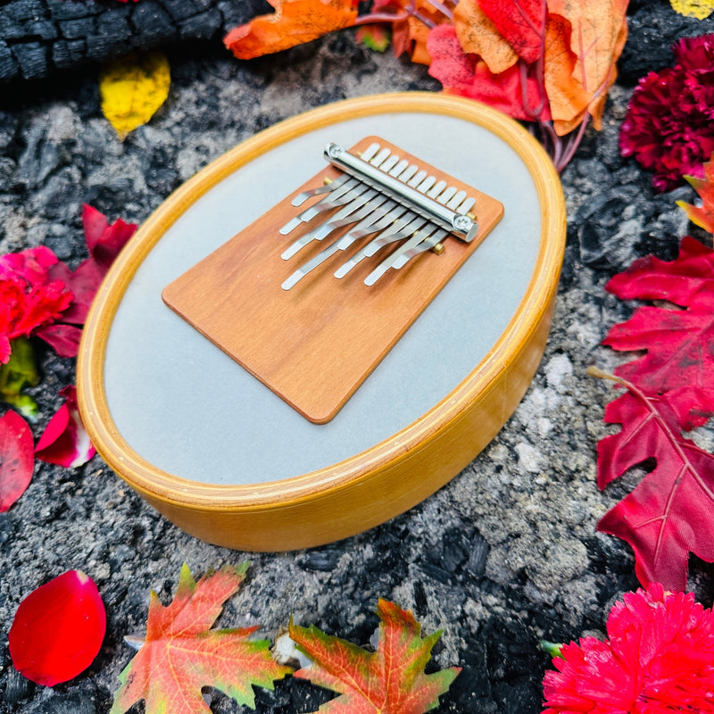 Hokema Sansula Renaissance kalimba by the campfire with fall leafs | weplaywelltogether