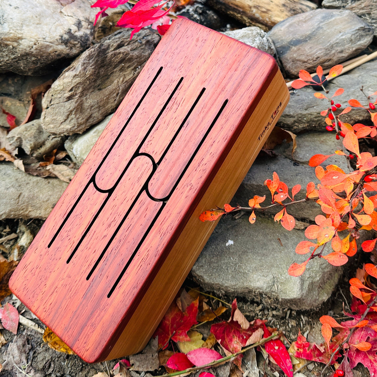 feetone Tinka Tong tongue drum in Fire tuning with mallets by the rocks | weplaywelltogether
