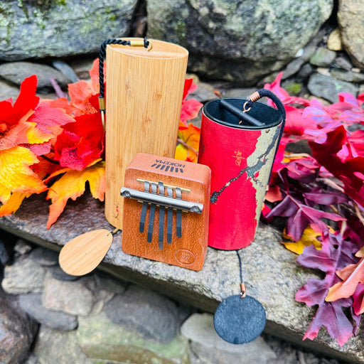 Koshi Ignis and red Zaphir  chimes with Hokema B5 Fire kalimba on a rock with fall leafs | weplaywelltogether