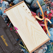 feeltone Monolina Monochord, stand and carrying case by the rocks | weplaywelltogether