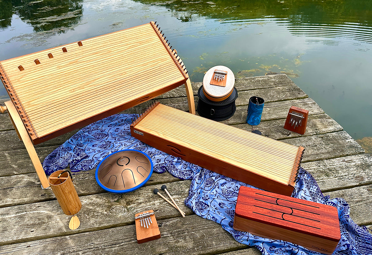 feeltone monochords and Tinka Tong - a wooden tongue drum, Zenko elemental metal tongue drum in Aqua tuning, Hokema Sansula Basic, B9 and B5 kalimbas, Blue zaphir  and Koshi Aqua chimes | weplaywelltogether