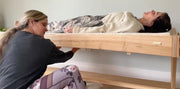 a person playing feeltone monochord table while another person is lying on the table | weplaywelltogether