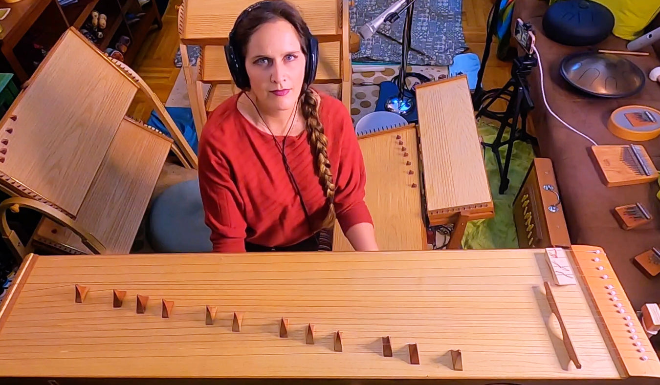Sound therapy practitioner Joule L'Adara surrounded with feeltone monochords. | weplaywelltogether