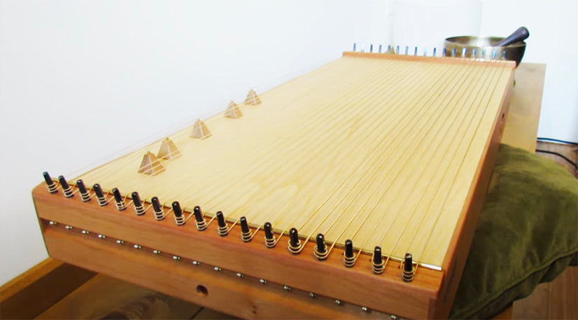 Monolina in D tuning. Monochord is a string instrument which has 21 strings with D tuning followed by 5 strings in octave lower D tuning followed by 5 strings with A tuning. Combines energizing overtones with the deeper tones of an octave and fifth tuning.   Lightweight and versatile, this monochord is designed so anyone can pick it up and play,   while also suitable for concert performances, sound baths, mediation and to accompany singing. | weplaywelltogether