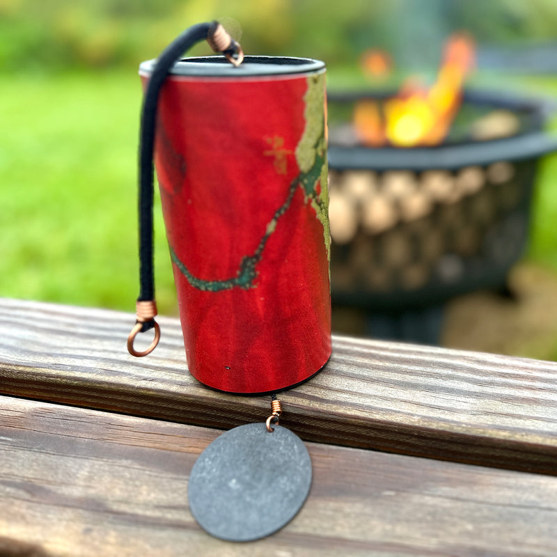 red  colored Zaphir chime  sitting on a balustrade in front of a fire pit   |Weplaywelltogether.