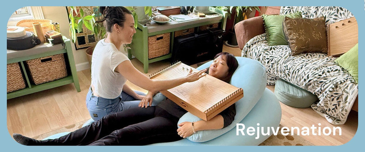 A woman playing feeltone monochord that is placed on top of another woman | weplaywelltogether