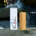 Koshi chime Aqua / water with a box on a rock by the water. | weplaywelltogether