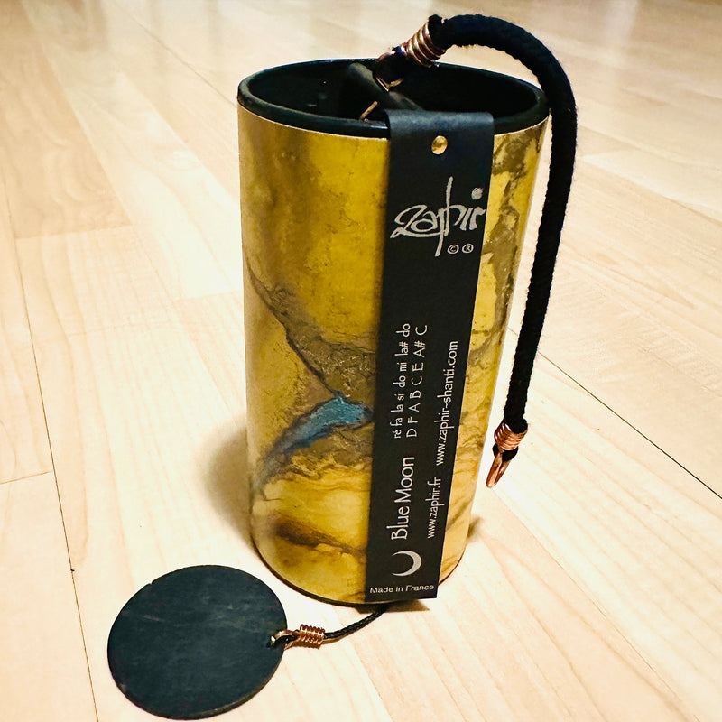 golden colored Zaphir chime sitting on a wooden floor |Weplaywelltogether.