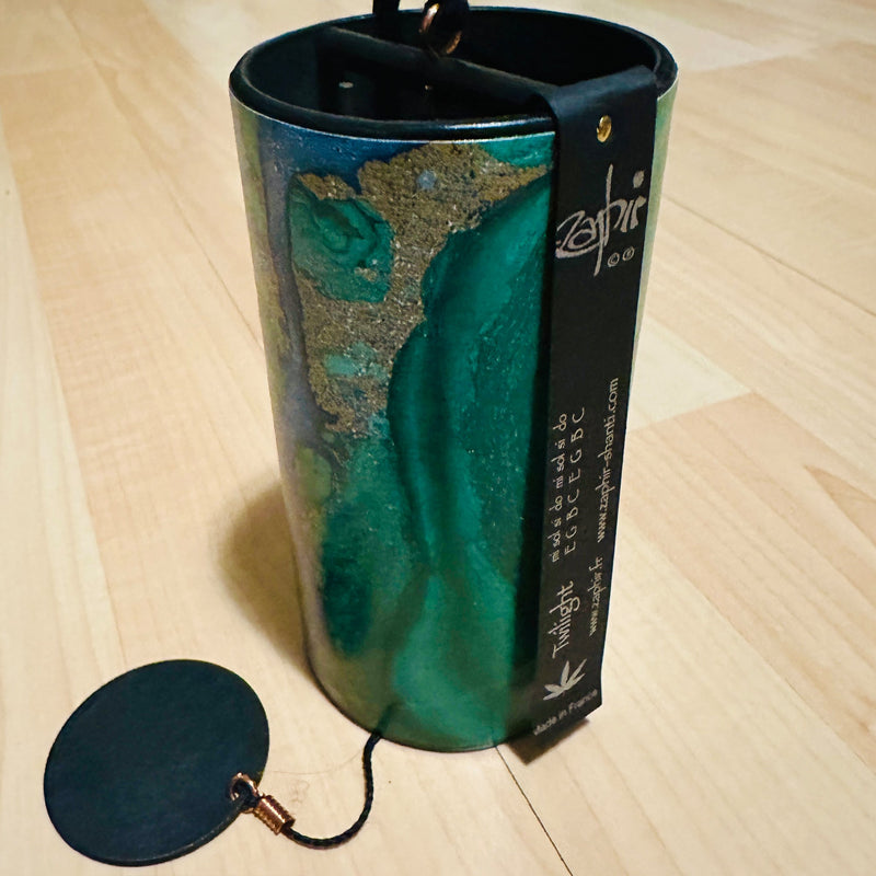 green colored Zaphir chime sitting on a wooden floor |Weplaywelltogether.