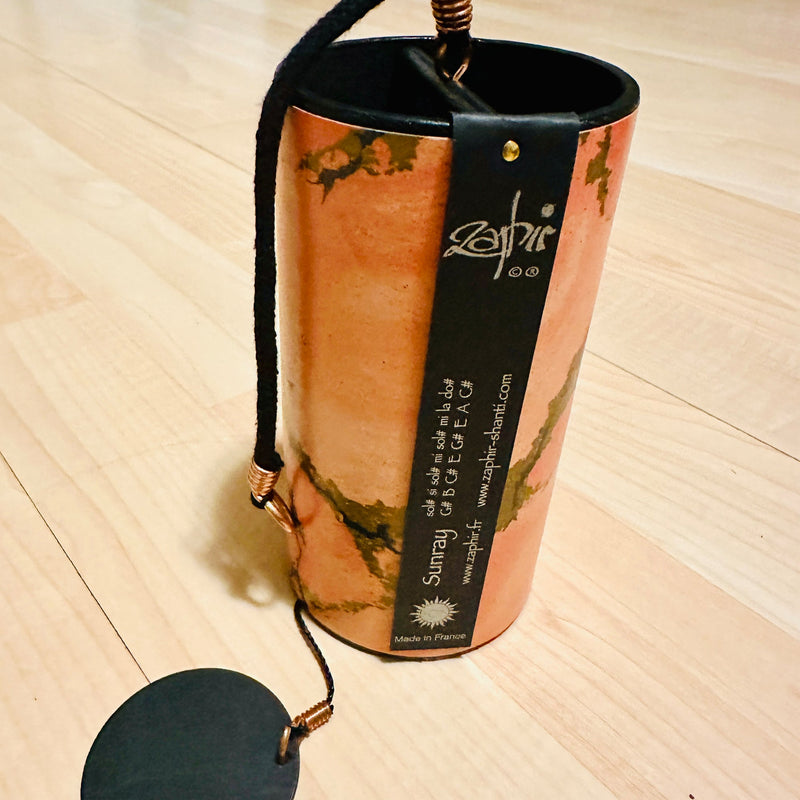 orange golden colored Zaphir chime sitting on a wooden floor |Weplaywelltogether.