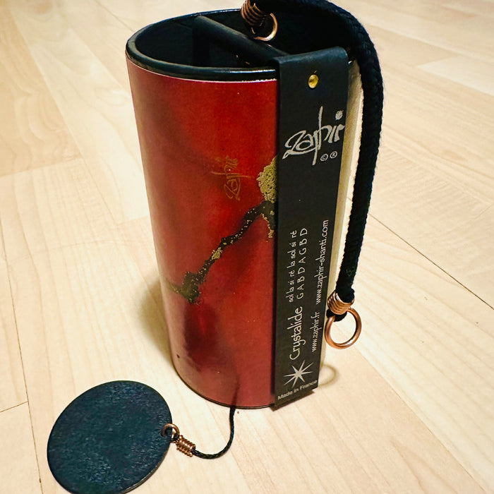 red colored Zaphir chime sitting on a wooden floor |Weplaywelltogether.