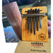HOKEMA B5 KALIMBA - Elemental Soundscapes Water Collection (D-minor) sitting on a wooden bench in front of a lake