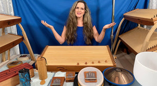 Joule L'Adara surrounded by feeltone monochords, Hokema Sansulas and kalimbas, Zenko elemental aqua tongue drum, feeltone aqua tinka tong, koshi chime and blue zaphir chime | weplaywelltogether